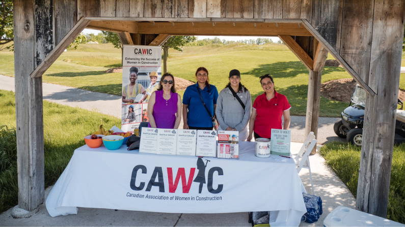 Four women from CAWIC behind their table at the golf tournament at Piper's Heath Golf Club, Milton, Ontario